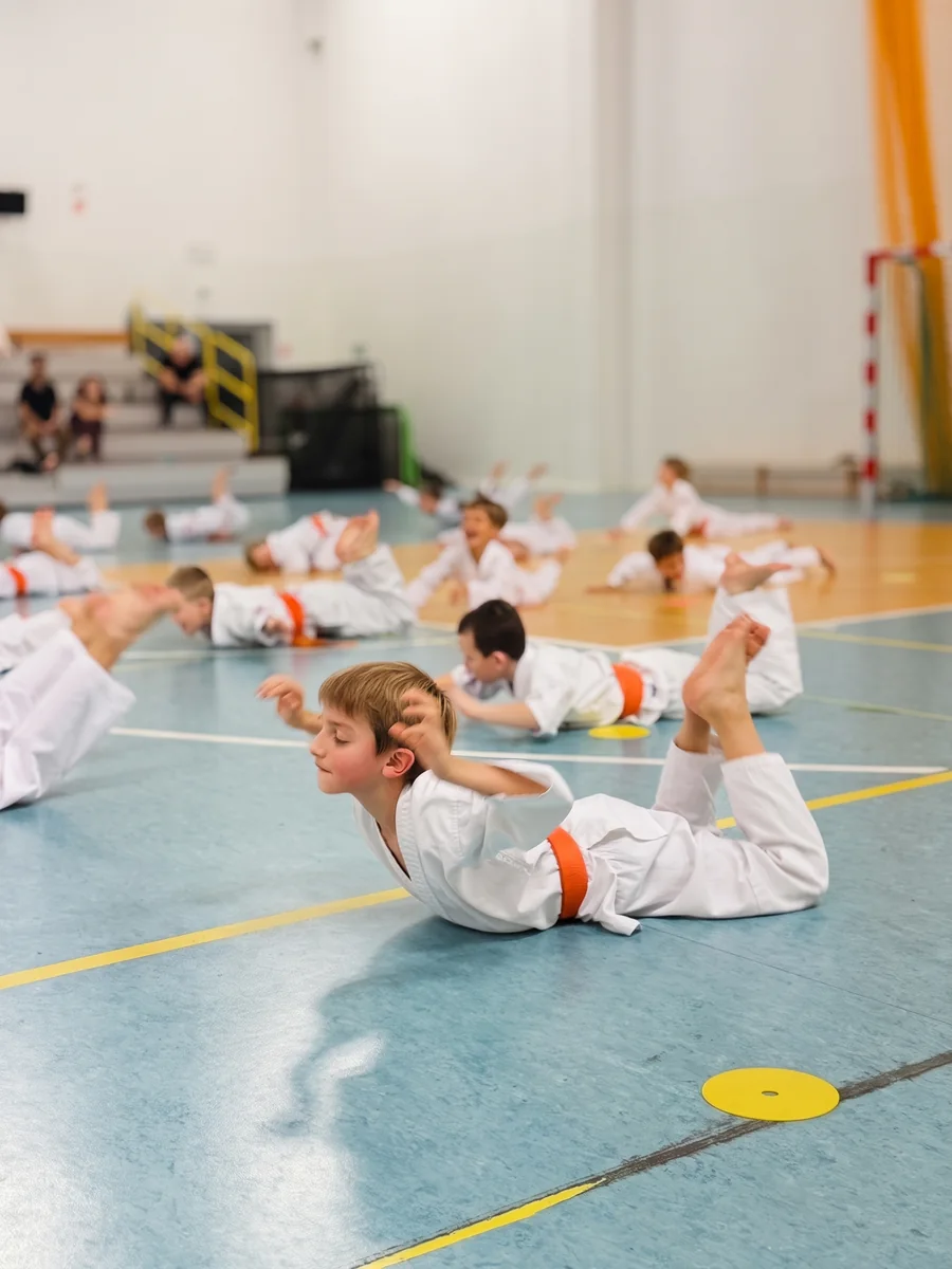 Dzieci ćwiczą na macie podczas rozgrzewki