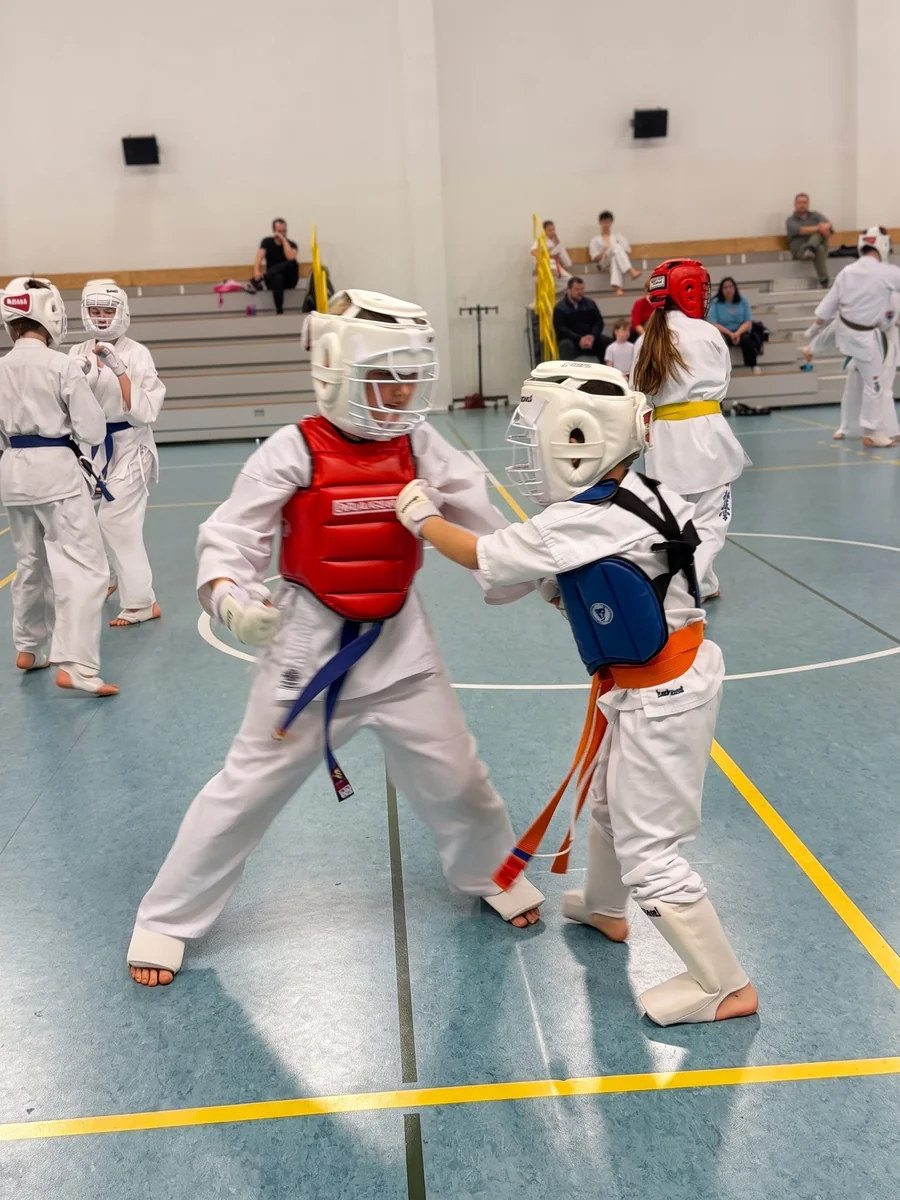 Walka kumite dzieci w kaskach i ochraniaczach