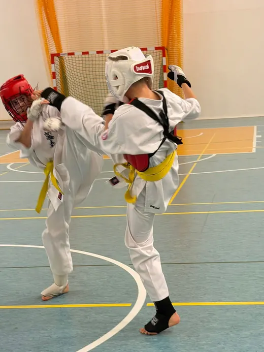 Walka kumite dwóch zawodników w kaskach