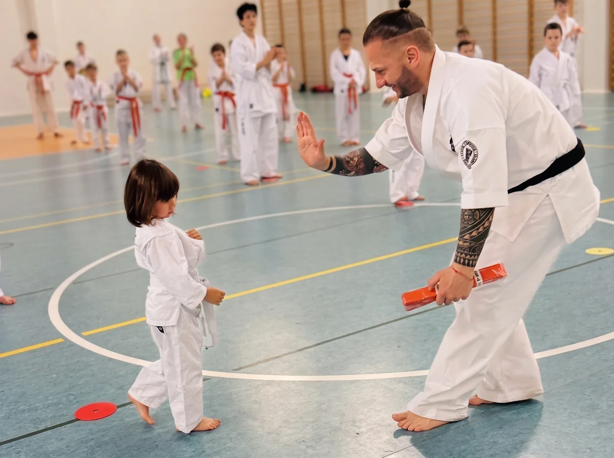 Sensei pokazuje technikę najmłodszej zawodniczce podczas treningu