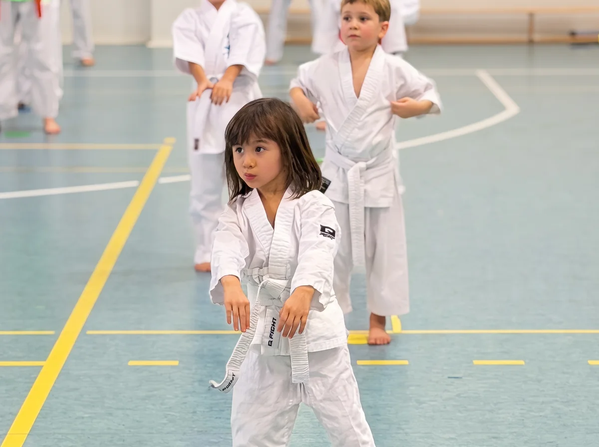 Najmłodsza zawodniczka klubu w białym karate gi na treningu